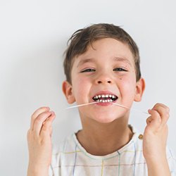 Little boy flossing his teeth
