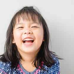 Close-up of little girl with patterned shirt smiling
