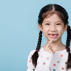 Girl smiling to reveal two missing teeth