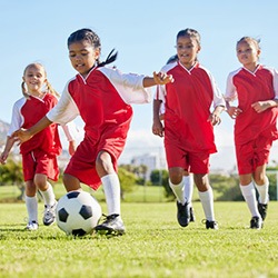 Girl playing soccer with teammates 
