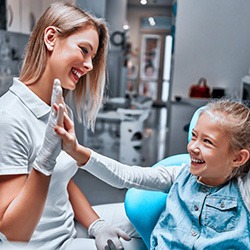 Dentist and little girl giving each other a high-five