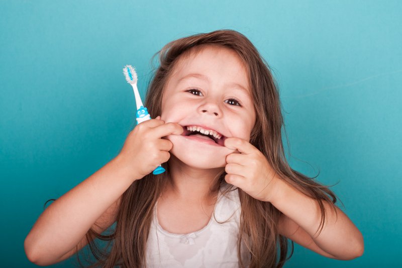 Child makes funny face with toothbrush