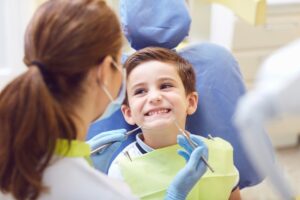 Dentist working with smiling child in dentist's chair.